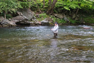 Woman standing on rock by river