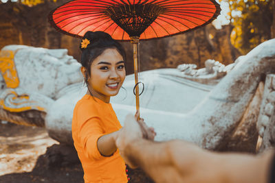 Portrait of young woman holding camera