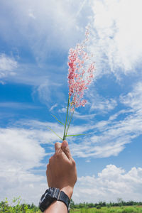 Man holding umbrella against sky