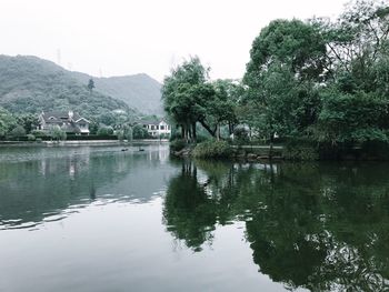 Scenic view of lake by trees against clear sky