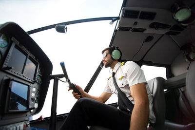 The pilot sits in the helicopter cockpit.