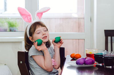 A little girl is painting eggs for the easter holiday.