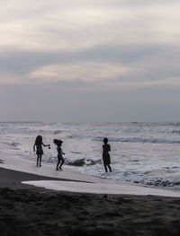 People on beach against sky