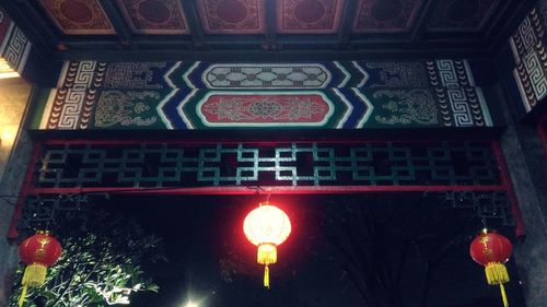 Low angle view of illuminated red lights at night