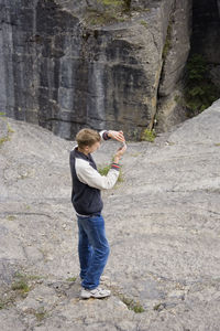 High angle view of man using phone while standing on mountain
