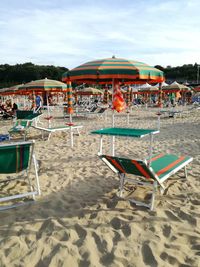 Chairs on beach against sky