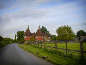 Road amidst buildings against sky