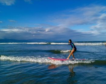 Man surfing in sea against sky