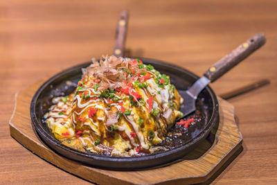 Japanese okonomiyaki covered with katsuobushi leek mayonnaise and bulldog sauce 