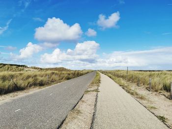 Empty road along countryside landscape