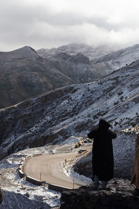 Rear view of person on mountain against sky