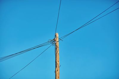 Low angle view of cables on bamboo against clear sky