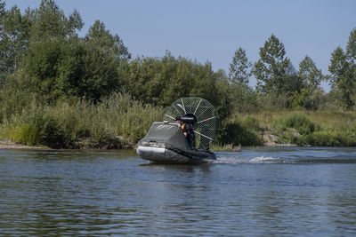 A chigh-speed riding in an airboat on the river on a summer day with splashes and waves