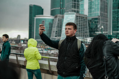 Friends standing against buildings in city