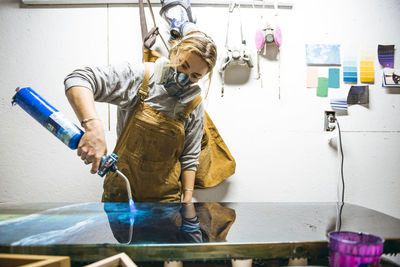 Female resin working in homemade studio with blowtorch