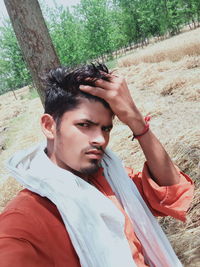 Portrait of young man lying on land