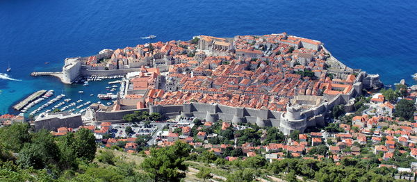 Aerial view of city by blue sea