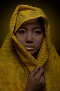 Close-up portrait of young woman in yellow scarf