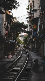 Railroad tracks amidst buildings in city