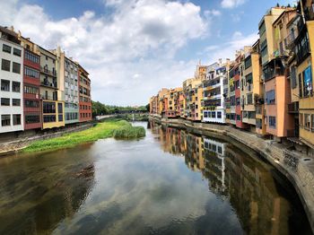 Canal amidst buildings against sky