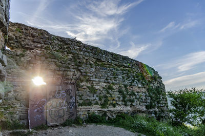 Stone wall of old building against sky