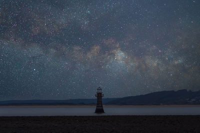 Lighthouse against sky at night