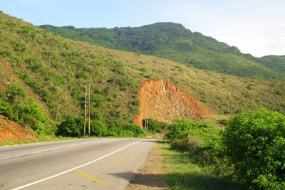 Road by mountain against sky