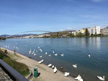 Scenic view of river by city against sky