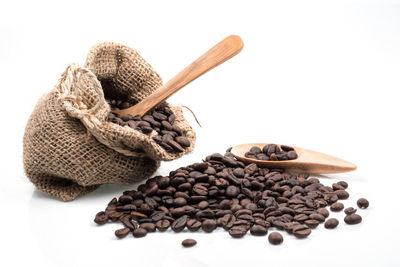 High angle view of roasted coffee beans against white background