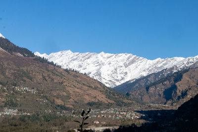 Scenic view of snowcapped mountains against clear blue sky