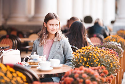 Smiling teenager girl looking away while sitting at restaurant