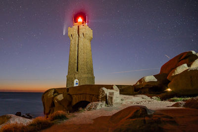 Built structure on beach against sky at night