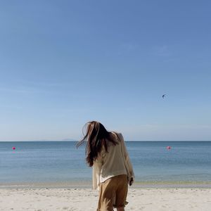 Women on beach against sky