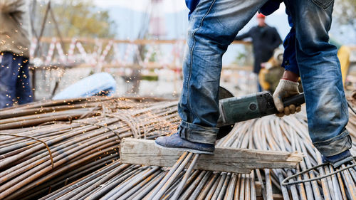 Low section of man working on wood at construction site