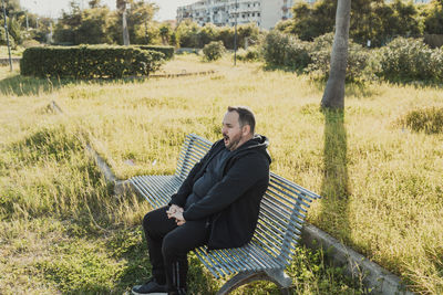 Young woman using laptop while sitting on field