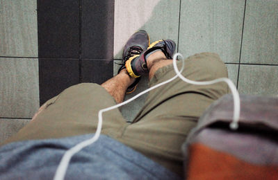 Low section of man standing on tiled floor