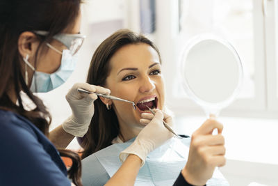 Dentist examining patient mouth in medical clinic