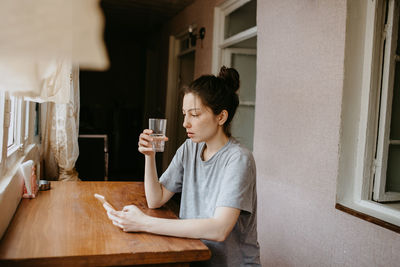 Young woman using mobile phone at home