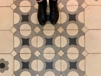 Low section of person standing on tiled floor