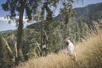 Man standing by tree on mountain