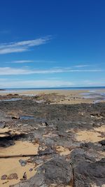 Scenic view of beach against blue sky