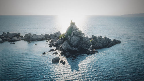 Rocks in sea against sky