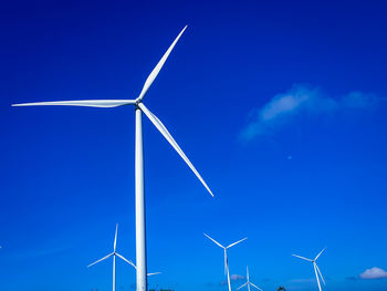 Low angle view of windmill against blue sky