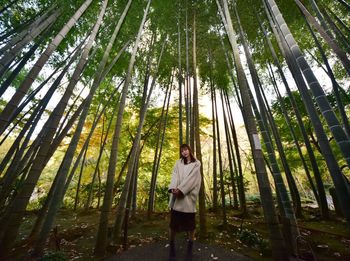 Full length portrait of woman standing amidst bamboo trees