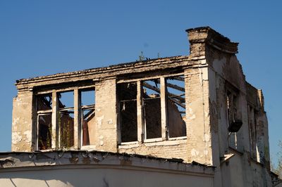 Low angle view of old building against clear blue sky