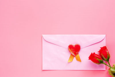 Close-up of pink flower on table against red background