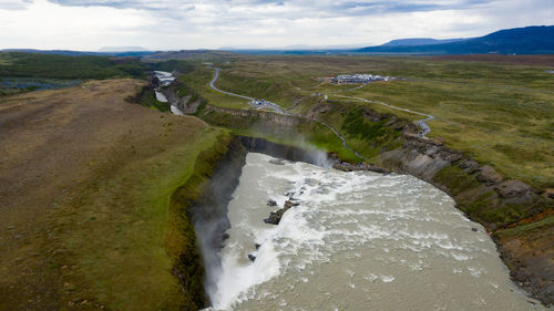 High angle view of flowing water on land against sky