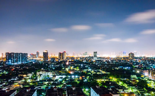 High angle view of illuminated buildings against sky at night