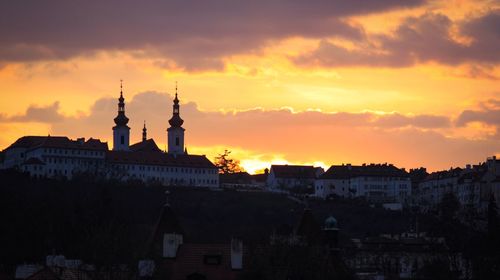 Silhouette buildings against sky during sunset