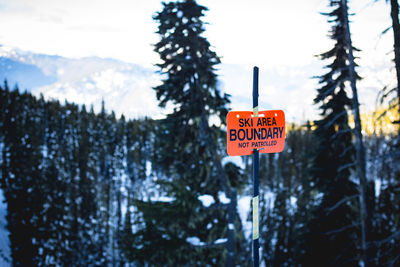 Close-up of information sign against sky